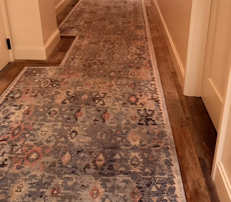 Freshly cleaned patterned runner rug in a hallway